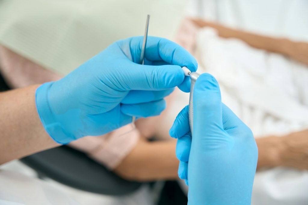 Dental specialist with drill in arms in stomatology center